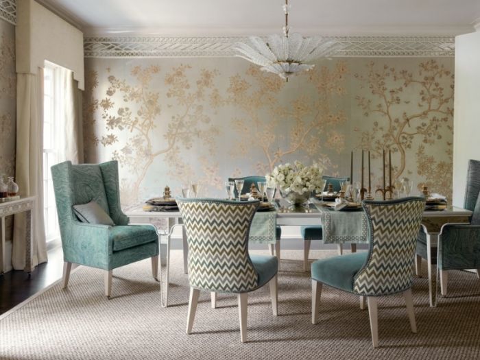 A dining room with blue chairs and wallpaper.