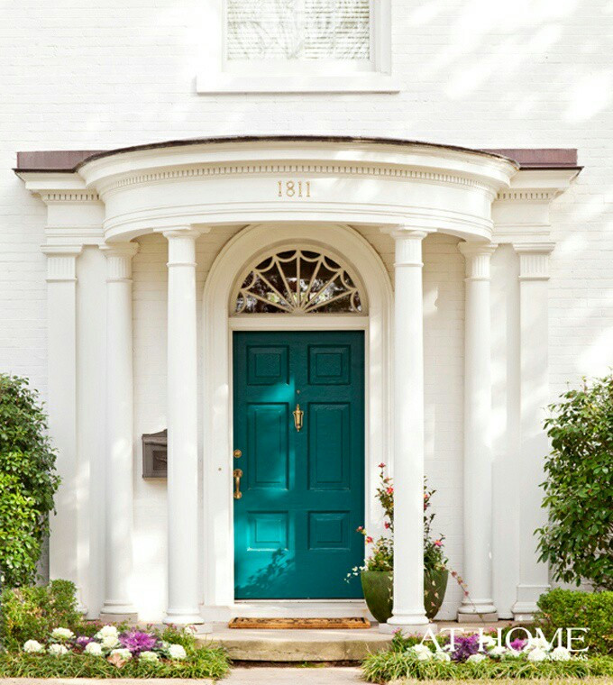 A house with a colorful door and classic columns.
