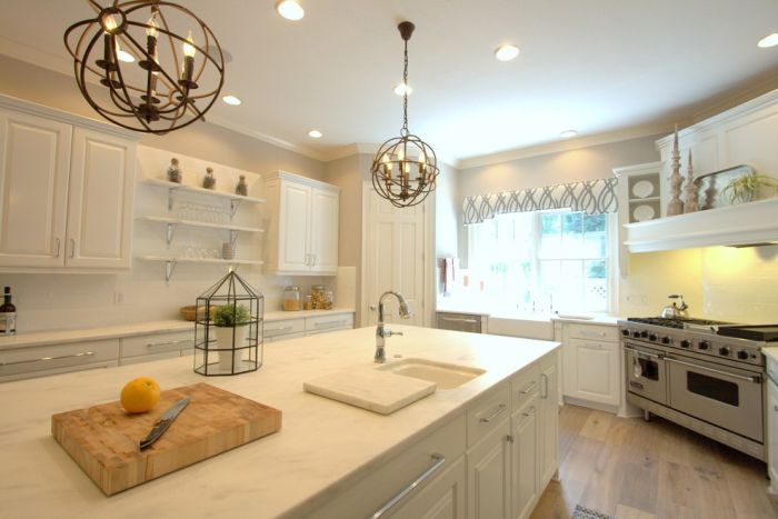 A kitchen with white cabinets and a large island showcasing classic paint colors.