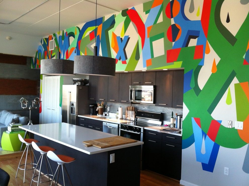 A pop art kitchen with a colorful mural on the wall.