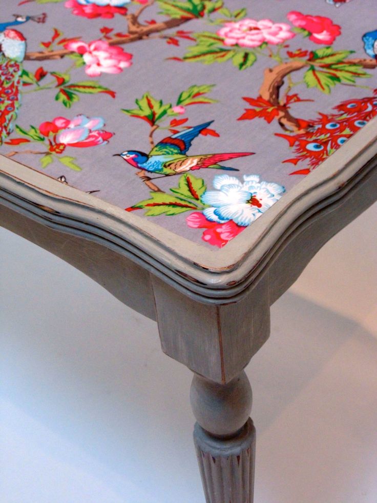 A coffee table with a floral pattern made from leftover wallpaper.