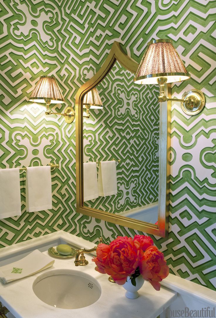 A tiny powder room with green and white patterned wallpaper.