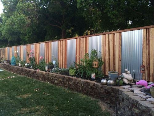 A backyard with a corrugated metal fence for increased privacy.