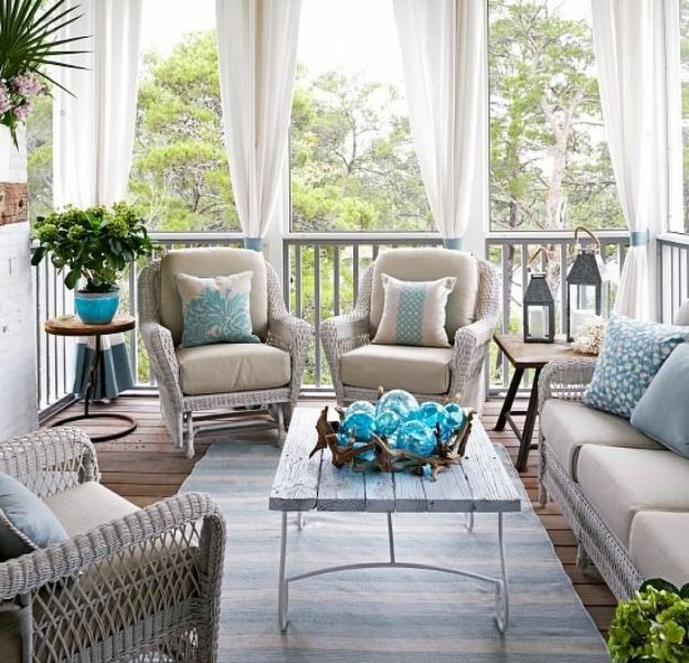 A screened in porch with wicker furniture in beach cottage style.