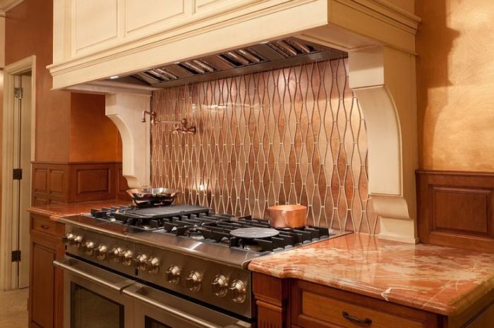 A copper kitchen with a stove and oven.