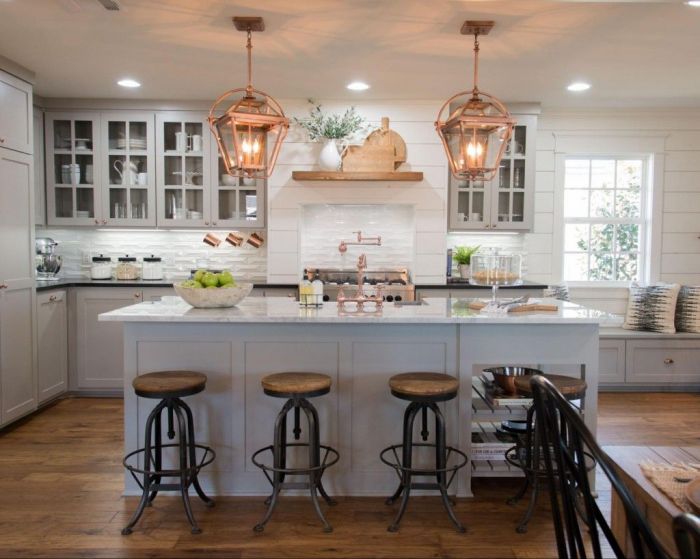 A copper kitchen with a large island and stools.