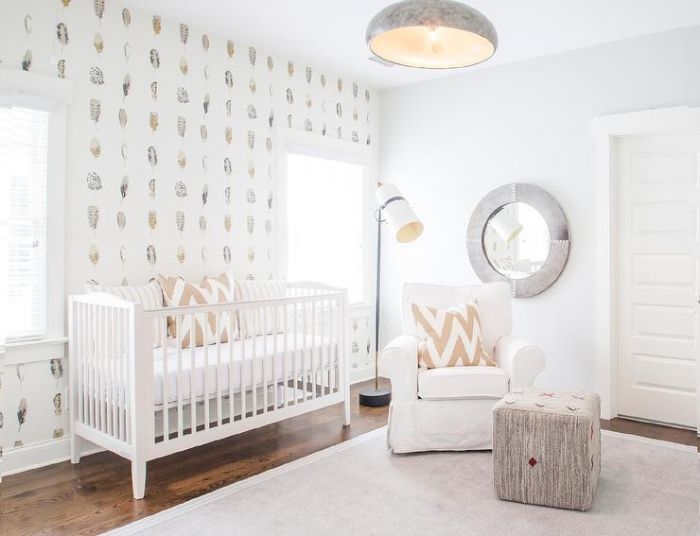 A gender-neutral nursery with a white crib and white wallpaper.