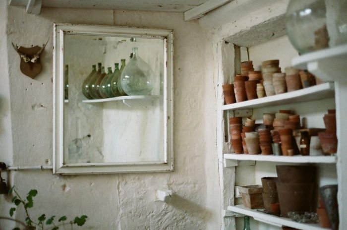 A wabi sabi mirror amidst an array of pots and vases.