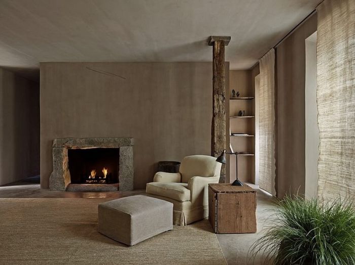 A wabi sabi living room with a fireplace and a chair.