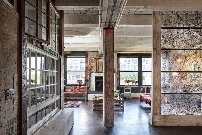 A living room in an industrial building with large windows designed in wabi sabi style.