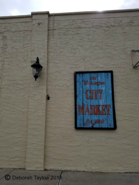 A sign on the side of a building in Wilmington that says city market.