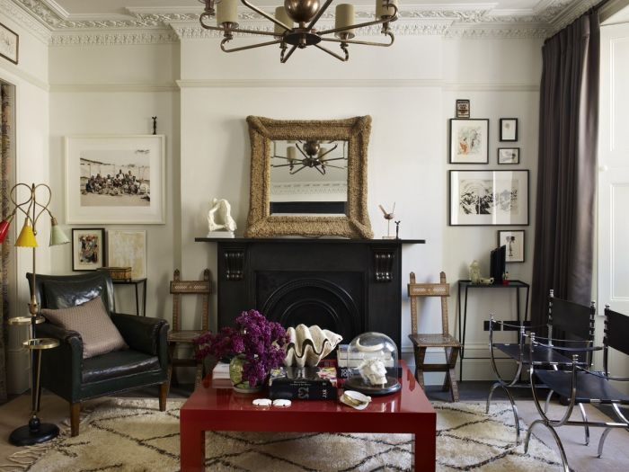 Designer tips: A living room with a fireplace and a red coffee table, designed for cozy ambiance.