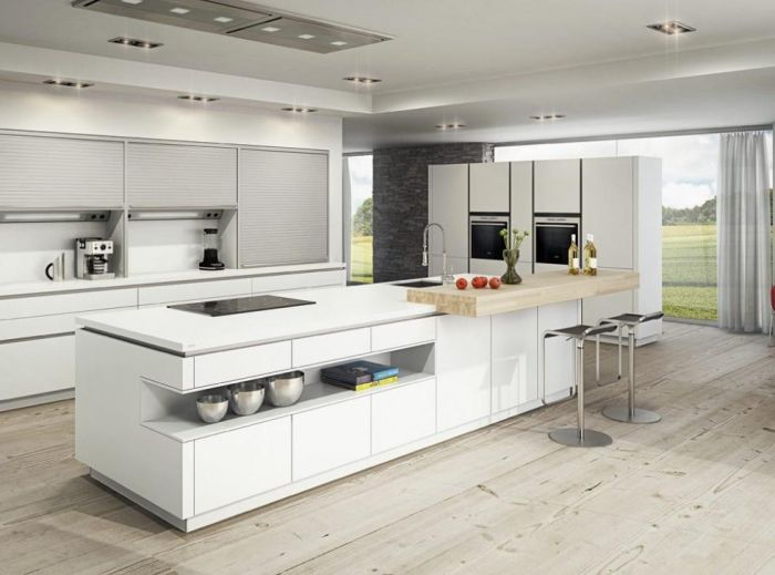 A modern kitchen with white cabinets and a wooden floor following Kitchen Design Trends.