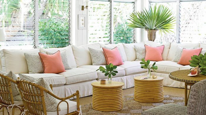 A white living room with island-style wicker furniture and pillows.