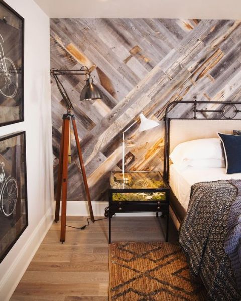 A bedroom with a wood accent wall.