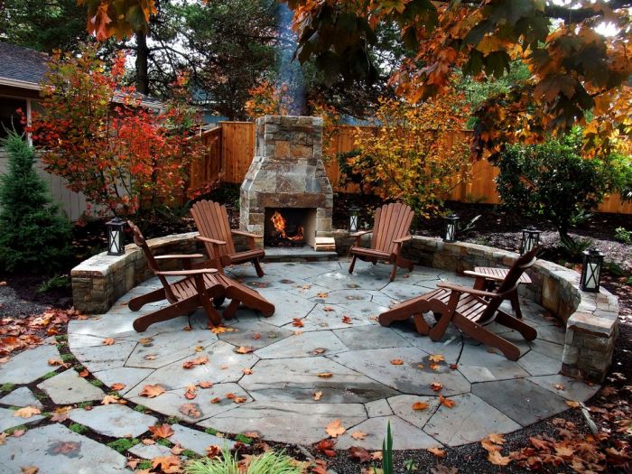 A stone patio with chairs and a fire pit.
