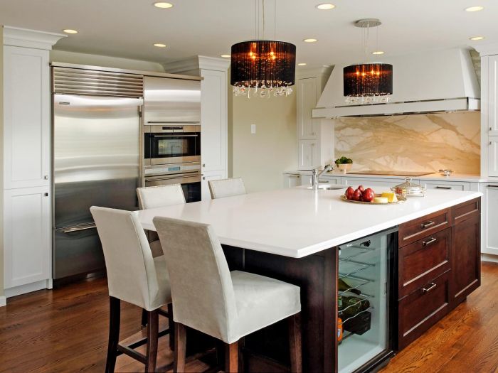 A kitchen with a large island and lighting.