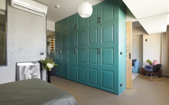 Designer tips for a bedroom with blue cabinets and a bed.