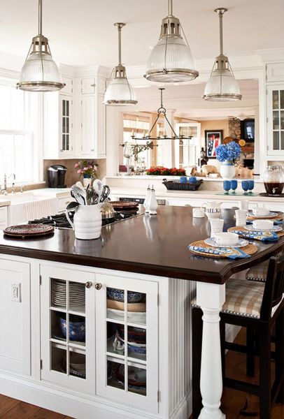 A white kitchen with a large center island and lighting.