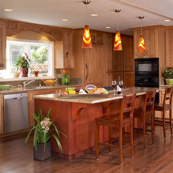 A kitchen with a center island illuminated by lighting.