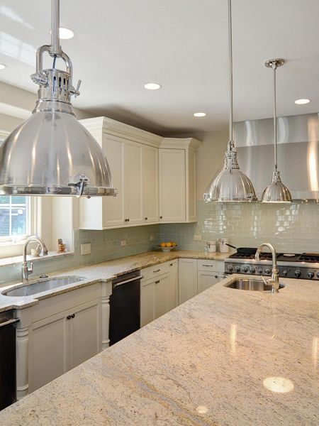 A kitchen with white cabinets, granite counter tops, and kitchen island lighting.