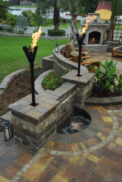Adding different levels and features such as water and light torches to the patio space can elevate the space (Pinterest)