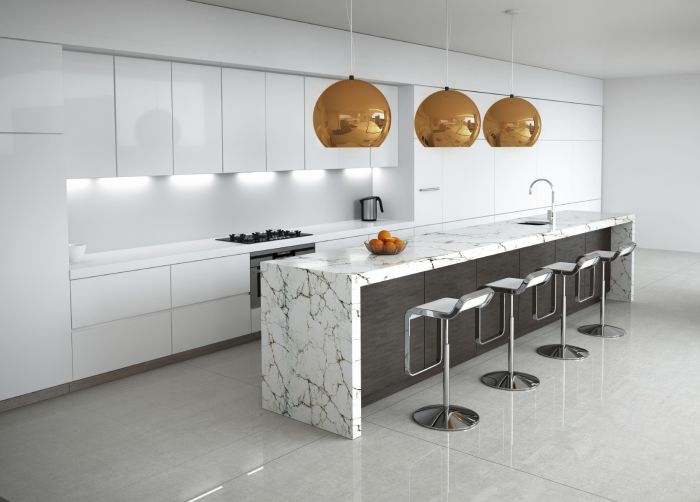 A modern kitchen with marble counter tops and kitchen island lighting.