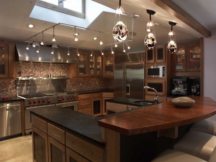 A kitchen with a wooden counter top and kitchen island lighting.