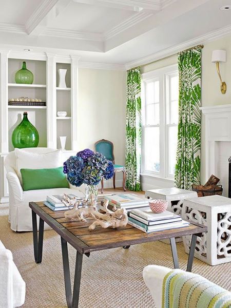 A living room with white furniture and island-style green accents.