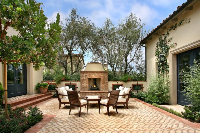 A brick patio with furniture and a fire pit.