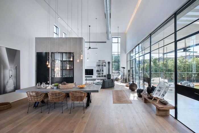 A modern loft with large windows and a dining table.