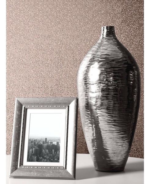 A metallic picture frame next to a vase on a table.