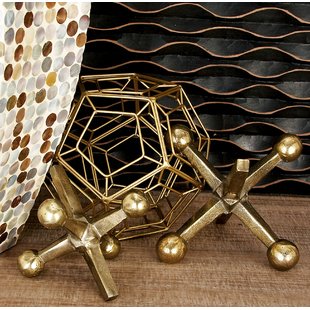 Designer tips for a set of brass spheres on a wooden table.