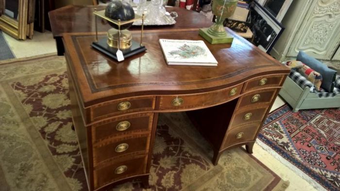 An antique desk with drawers and a vase that can serve as an investment.