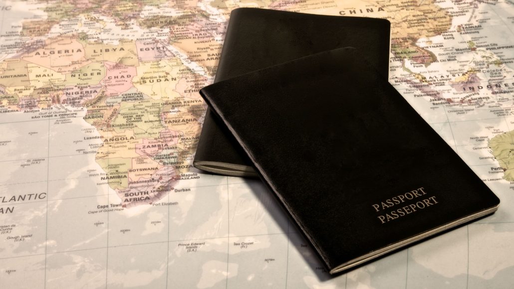 Two passports featuring international moving tips on top of a world map.