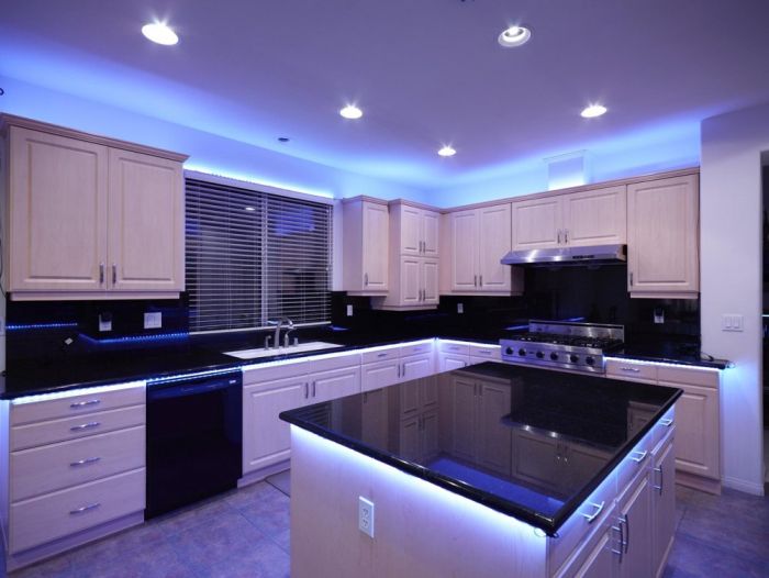 A kitchen with blue LED lights on the countertop, emphasizing innovative lighting.