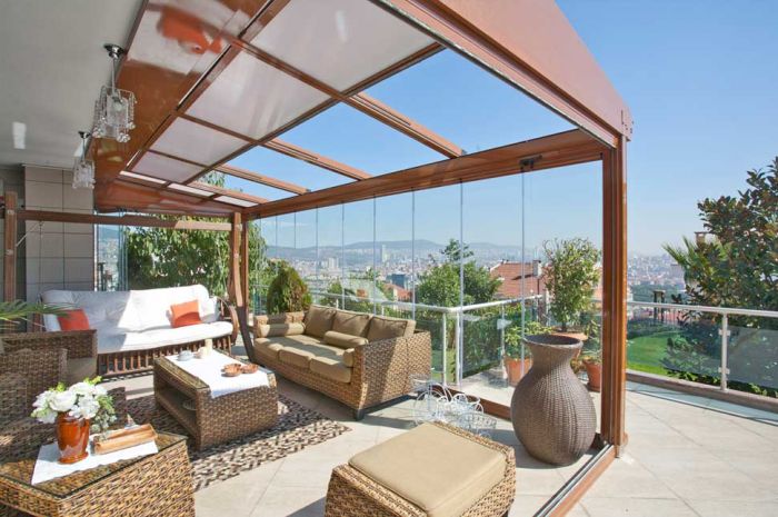 A patio with wicker furniture and a view of the city, featuring a retractable roof.