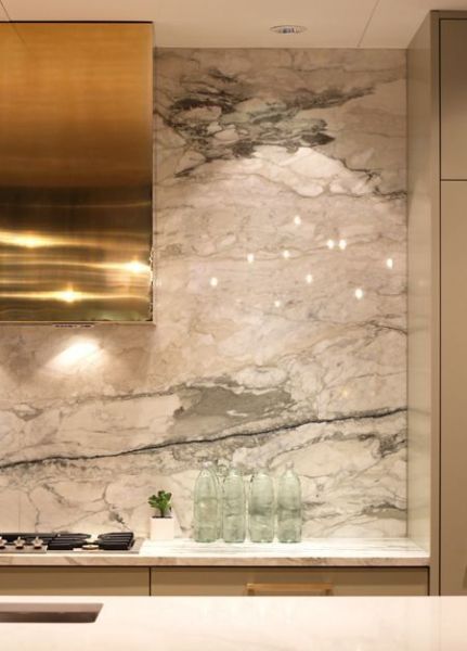 Marble backsplash and gold pendant lights in a kitchen.