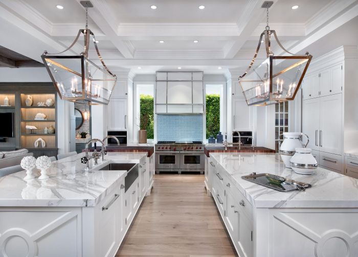 A white marble kitchen with a large island.