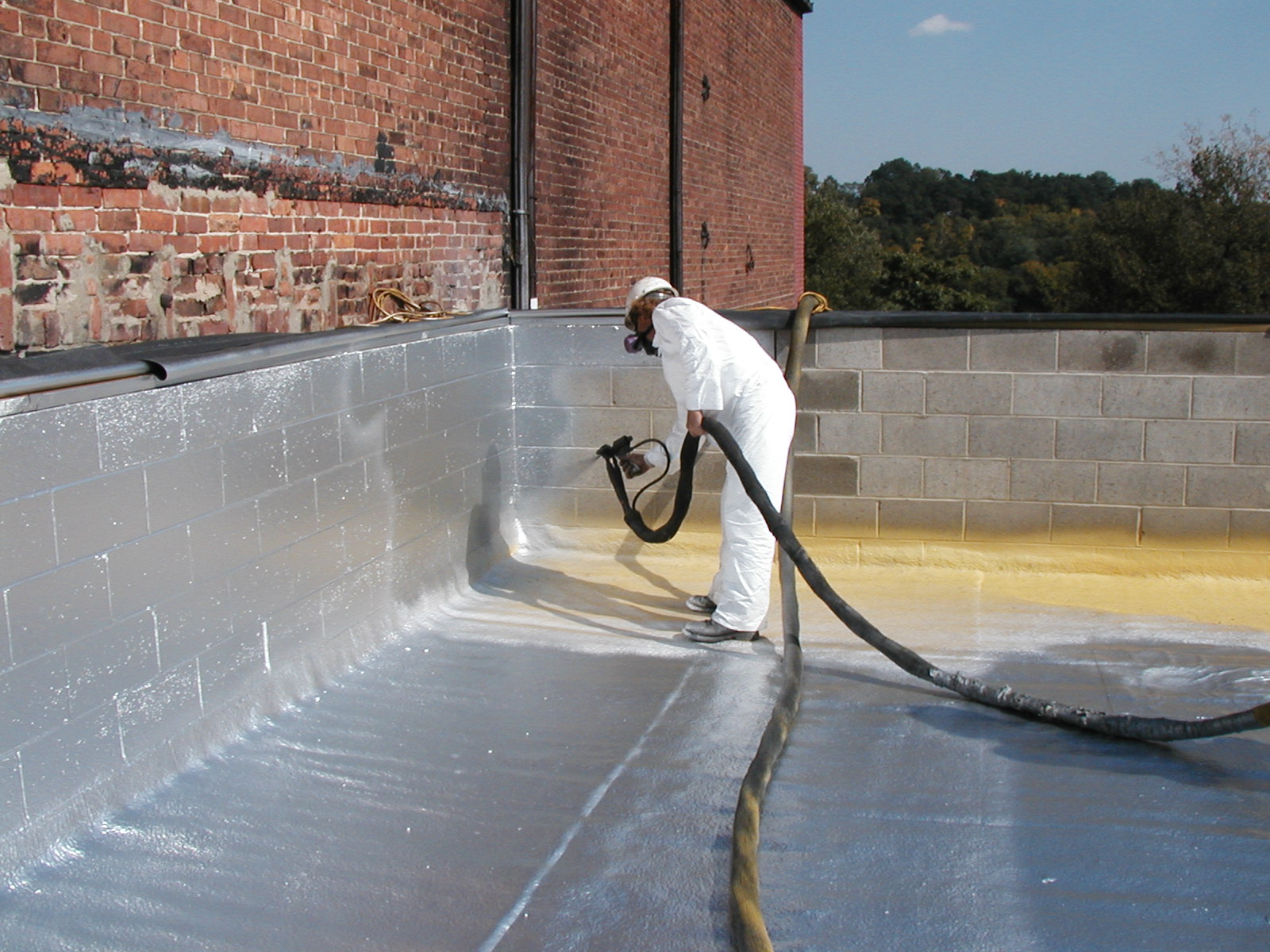 A man is applying waterproof coatings to a roof.