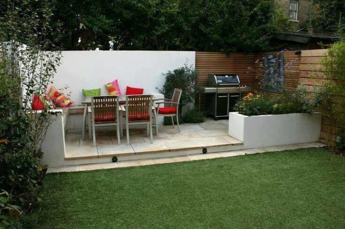 A small backyard patio with a table and chairs.