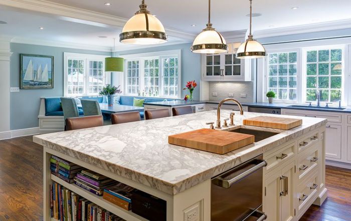 A kitchen with a large island and updated white cabinets.