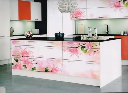 A kitchen with pink flowers on the counter top and changed surfaces.