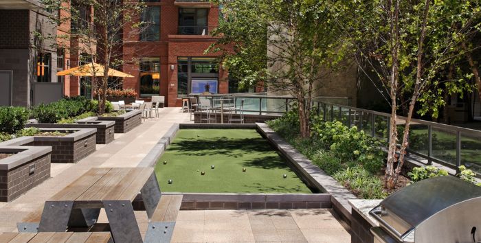 An outdoor patio with a bocce ball court designed by a landscape architect.