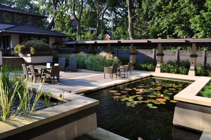 A modern backyard designed by a landscape architect with a pond and patio.