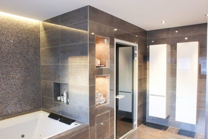 A modern spa bathroom with tiled walls and a bathtub.