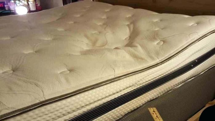 A bed with a mattress pad.