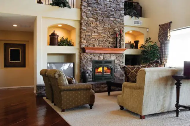 Cozy living room with stone fireplace and comfortable chairs.