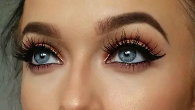 Close-up of woman's eyes with makeup and long lashes.
