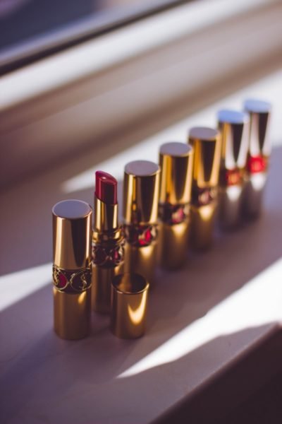 A row of gold lipsticks on a beauty counter.